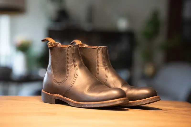 Red Wing Chelsea in dark leather seen at an angle from the front on a wooden table
