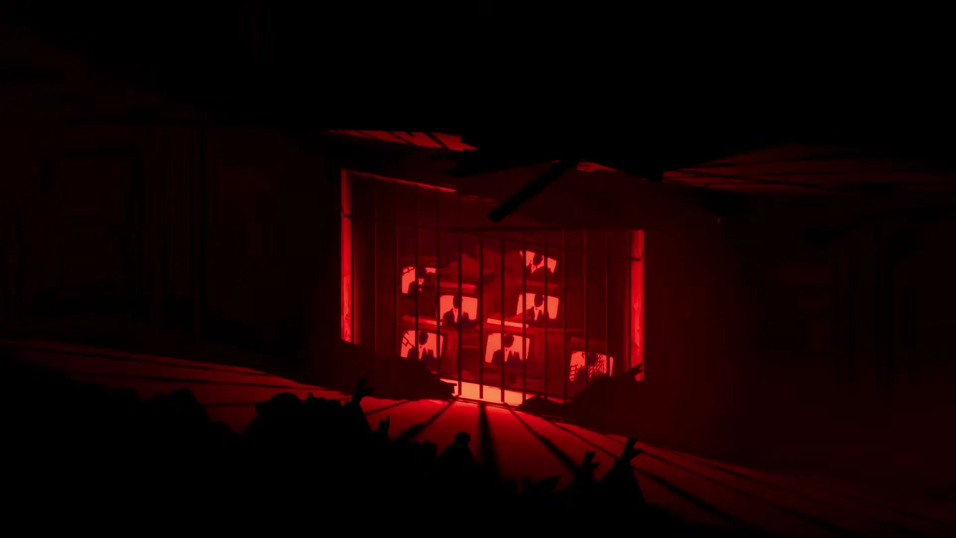 A red-lit room with stacks of old TV screens behind bars in Silver Pines