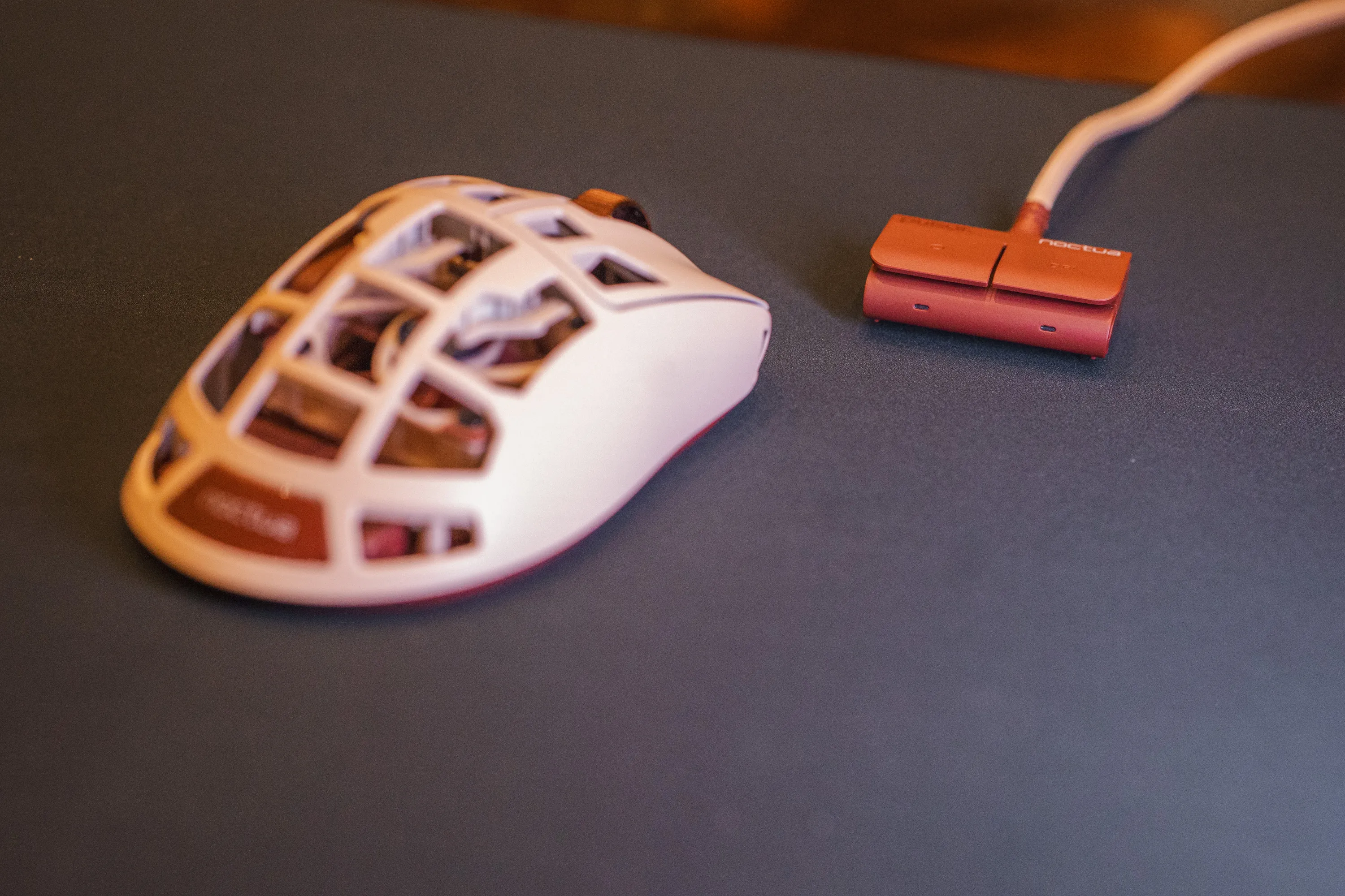 Feinmann F01 Noctua Edition and the brown receiver on a dark mousepad, photographed low from the side