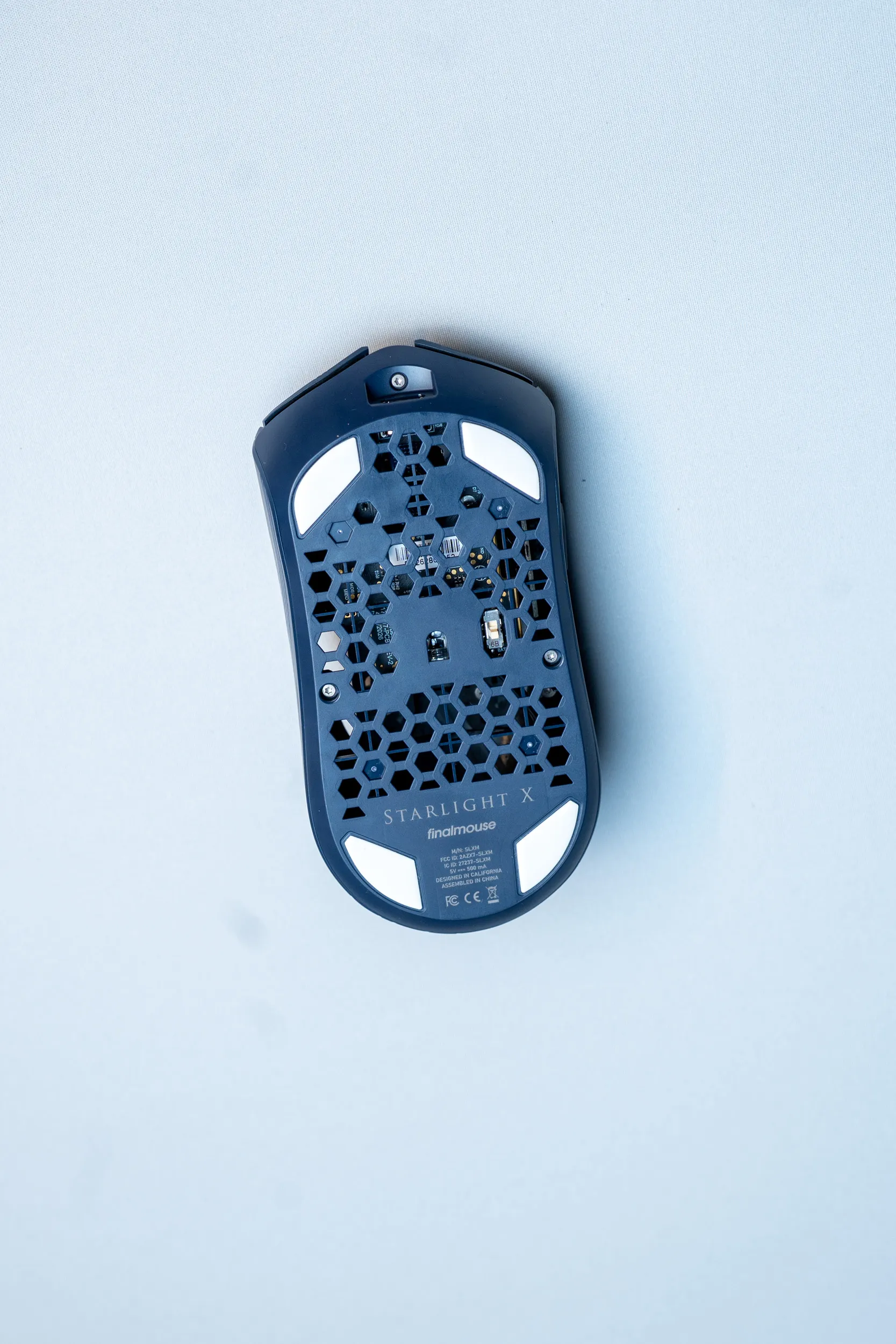 The underside of the Finalmouse SLX with a hexagon pattern, four white skates and the Starlight X logo