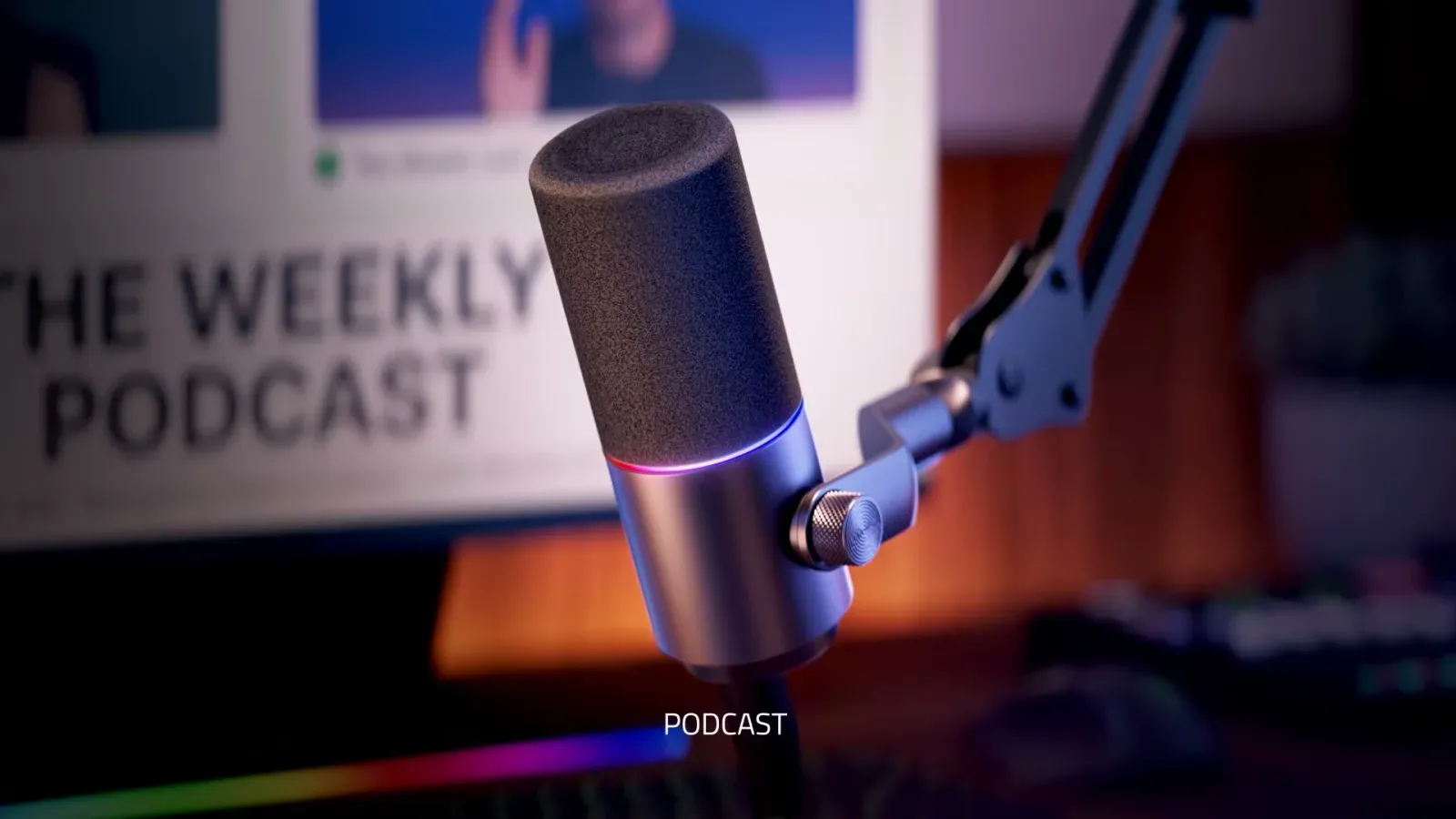 Razer Seiren V3 Pro on a boom arm in front of a screen showing a podcast recording