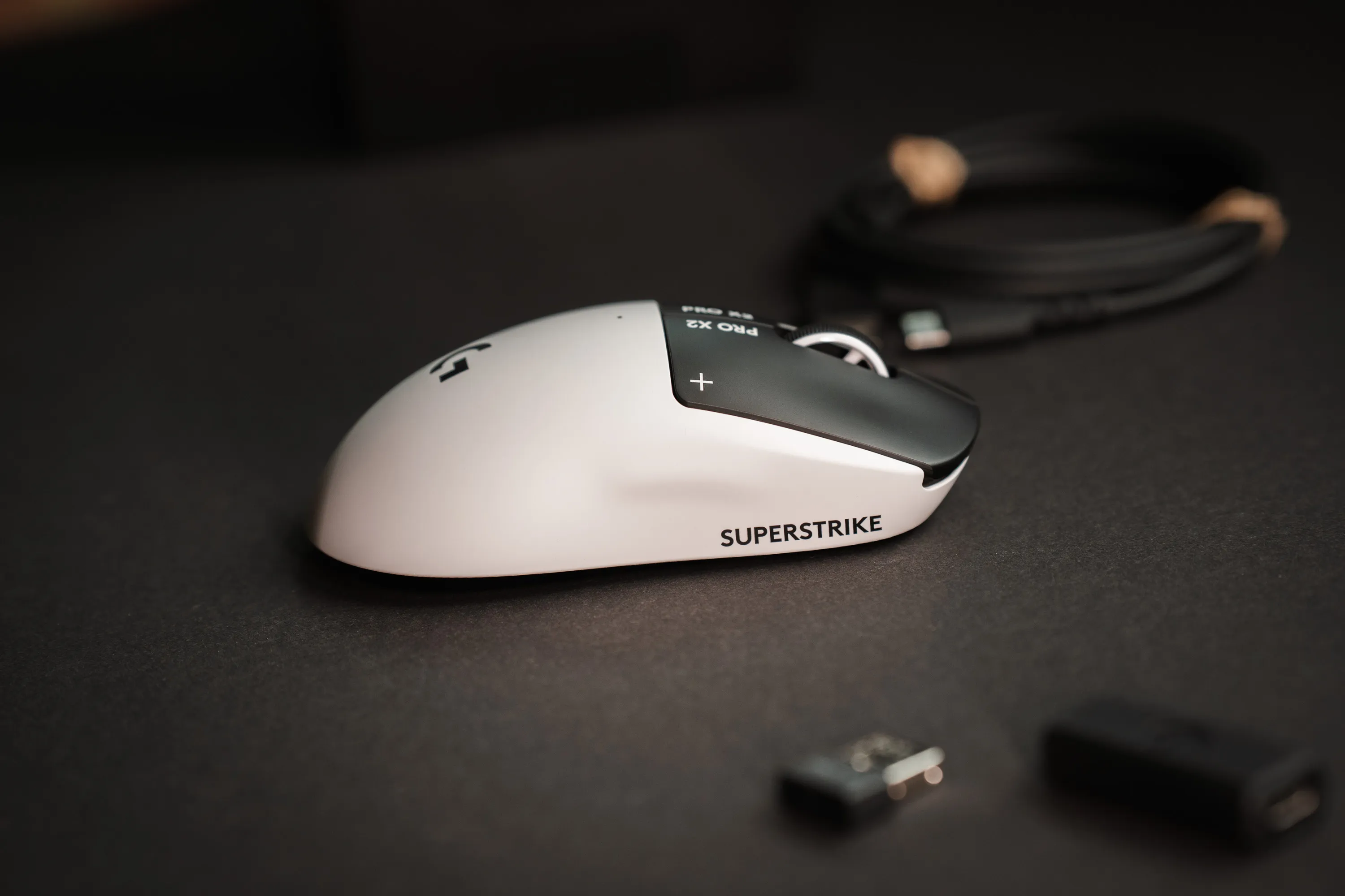 Logitech G Pro X2 Superstrike on the desk with the receiver and adapter in the foreground